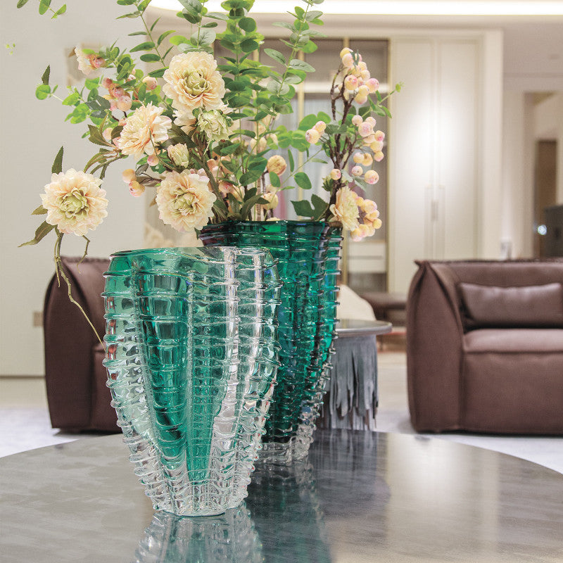 Close up of emerald green textured glass vase with flowers