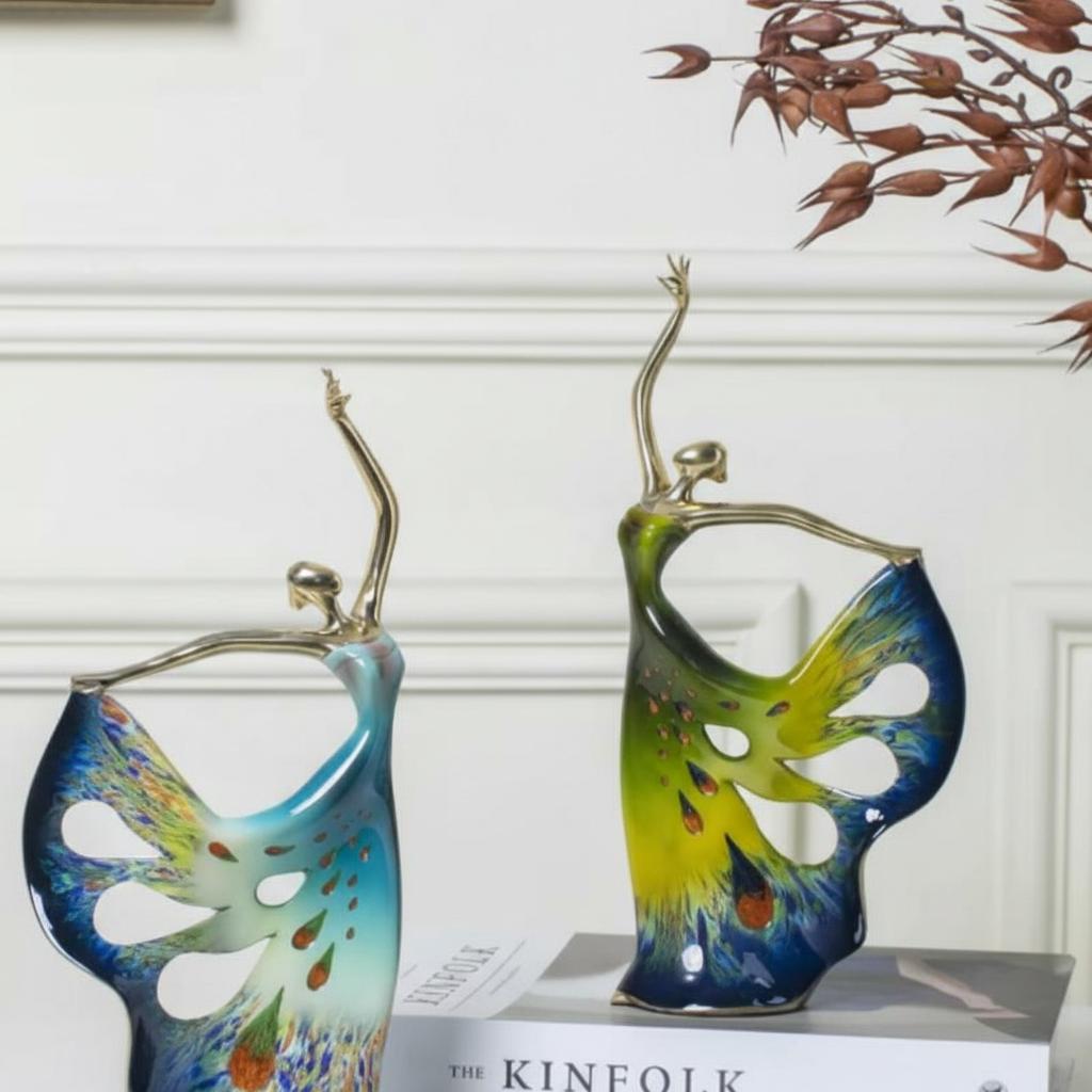 Abstract copper dancer sculpture with peacock feather motif on book stack