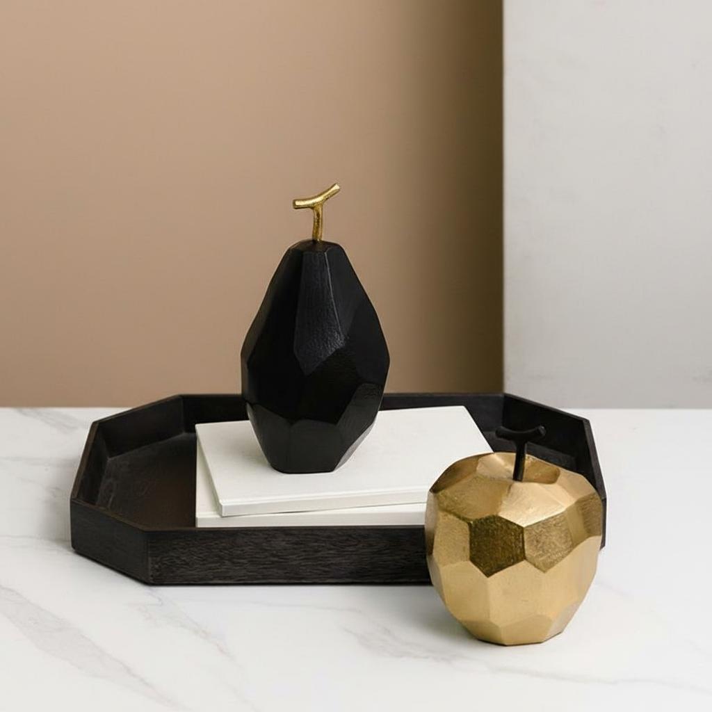 Faceted aluminum apple and pear sculptures on tray