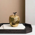 Geometric gold apple decor on dark wooden tray