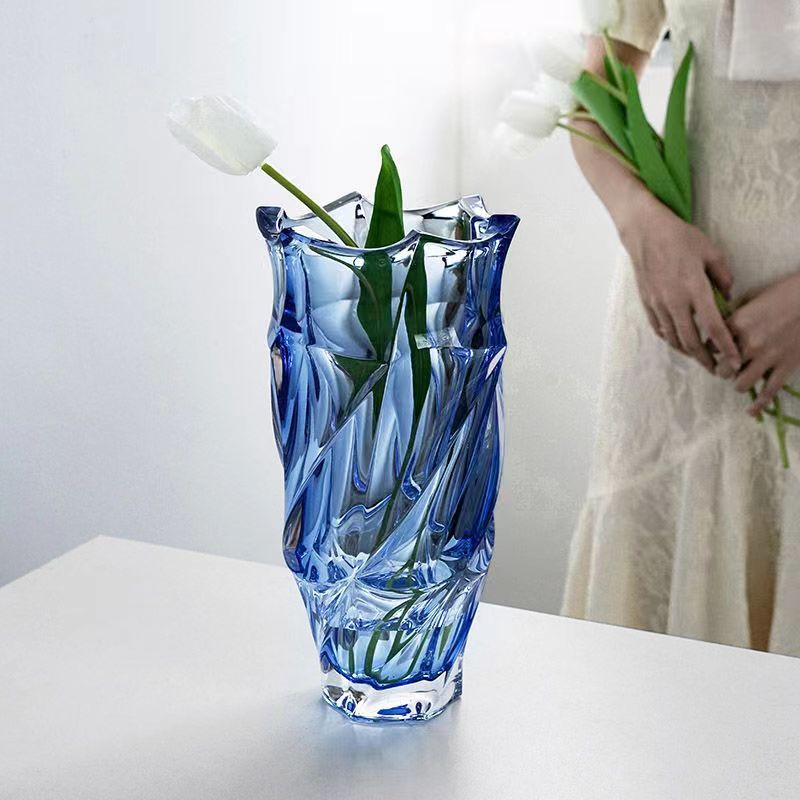 Blue faceted glass vase with white tulips