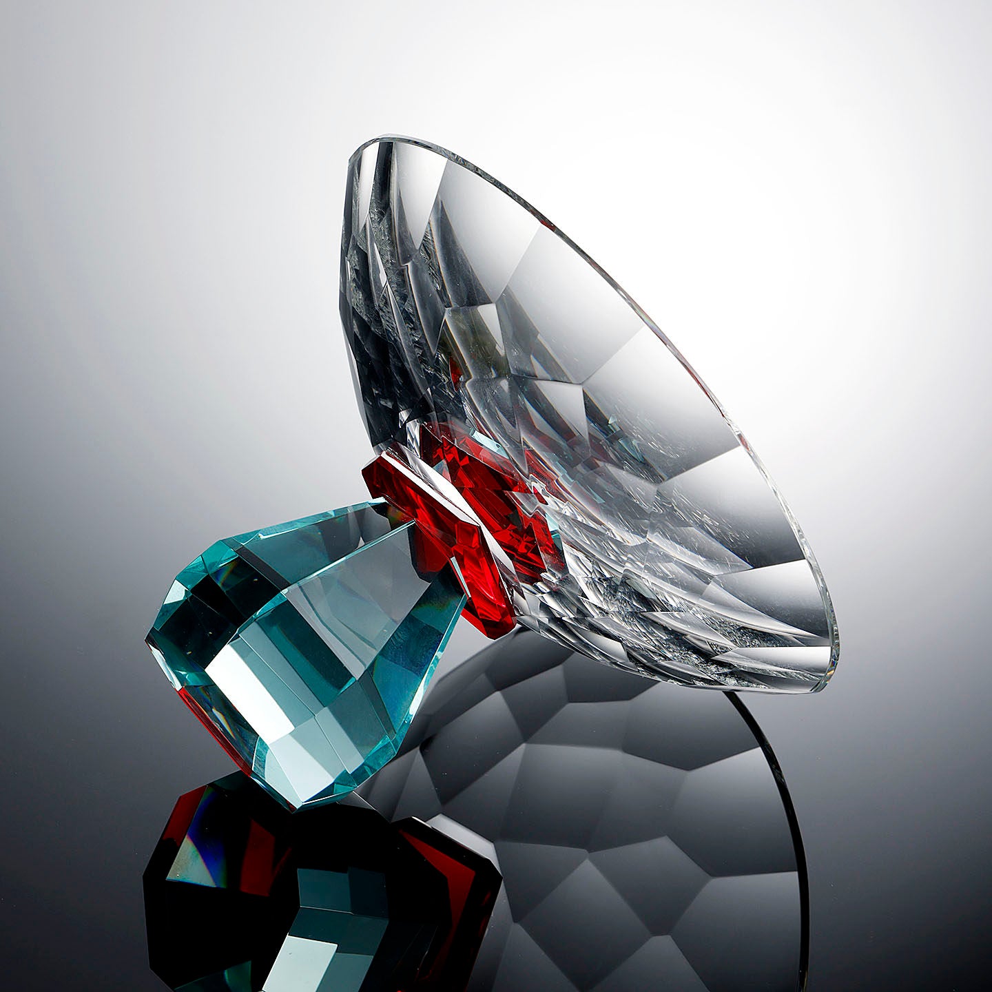 Side angle of geometric crystal centerpiece bowl highlighting faceted glass design and teal base