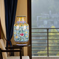 Floral blue and yellow ceramic vase on stand in luxury room setting