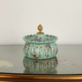 Mint green scalloped ceramic jar with floral patterns and gold copper finial