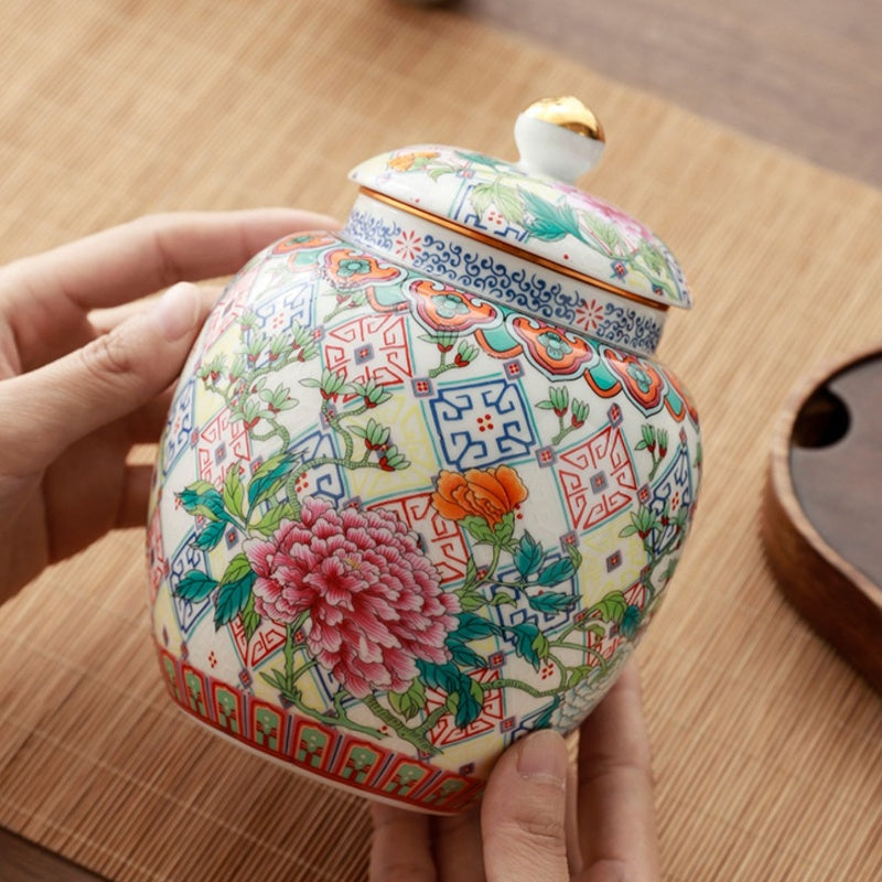 Hand holding floral ceramic jar showing scale and pattern details