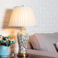 Floral ceramic table lamp with pleated shade on table