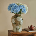 Lifestyle view of vase with blue flowers on wooden cabinet