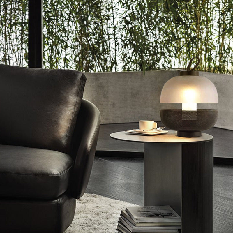Illuminated frosted glass table lamp in dark lounge setting