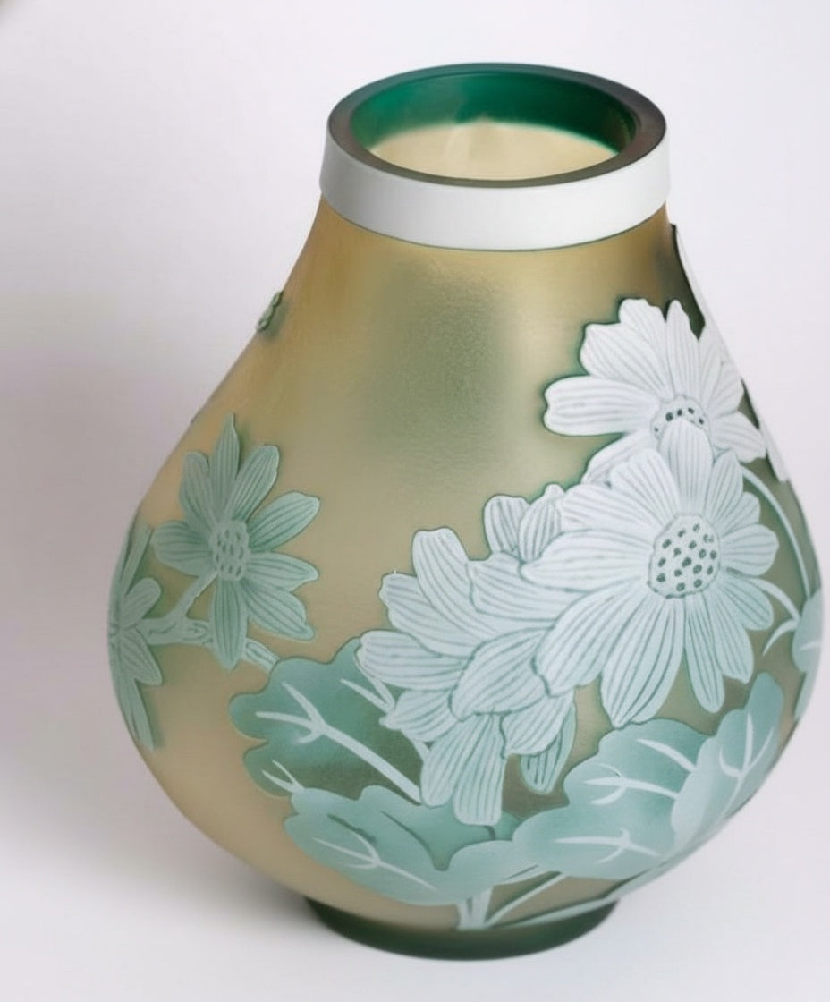Close up detail of raised floral patterns on green art glass vase