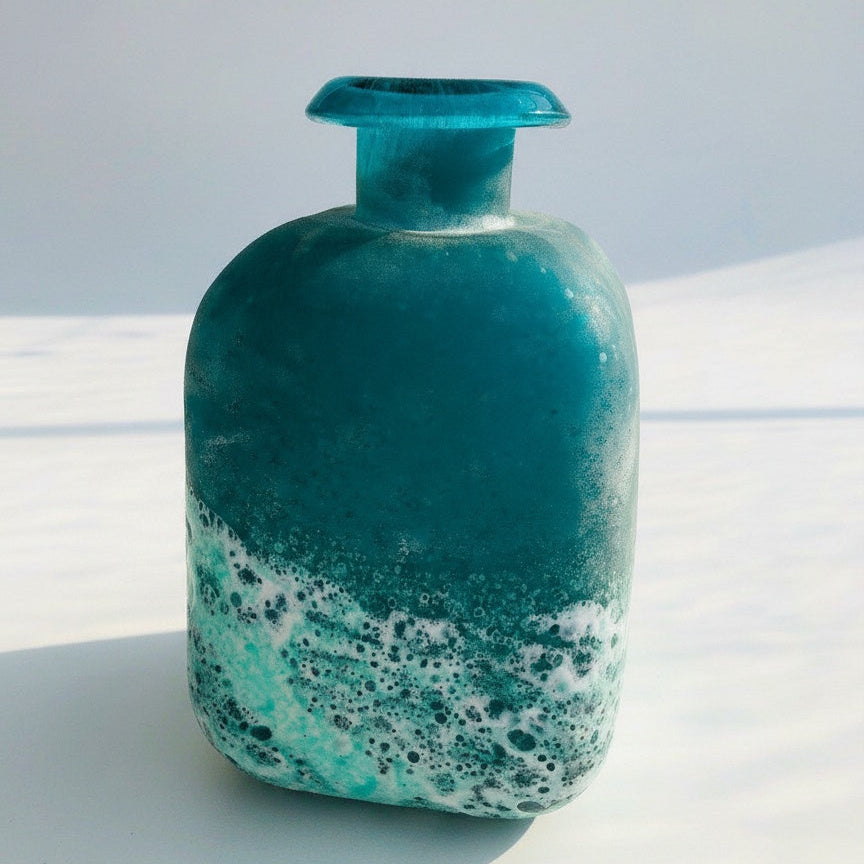 Angled view of teal and white glass bottle vase