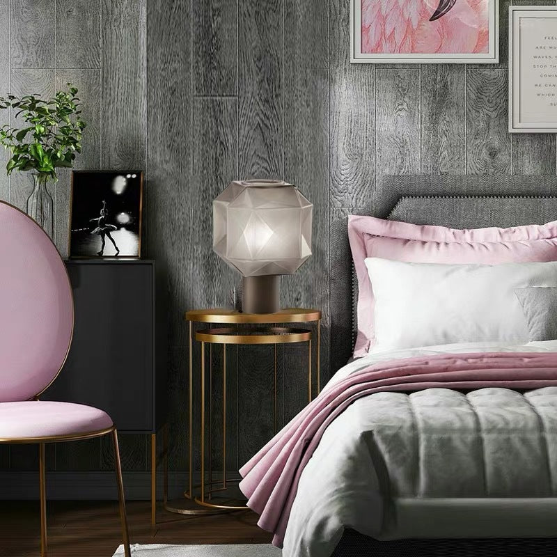 Cozy bedroom interior with a faceted glass table lamp on a gold bedside table