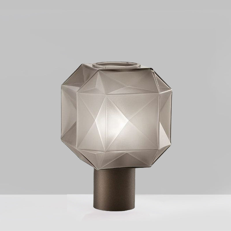 Close up detail of the faceted smoked glass shade and bronze cylindrical base