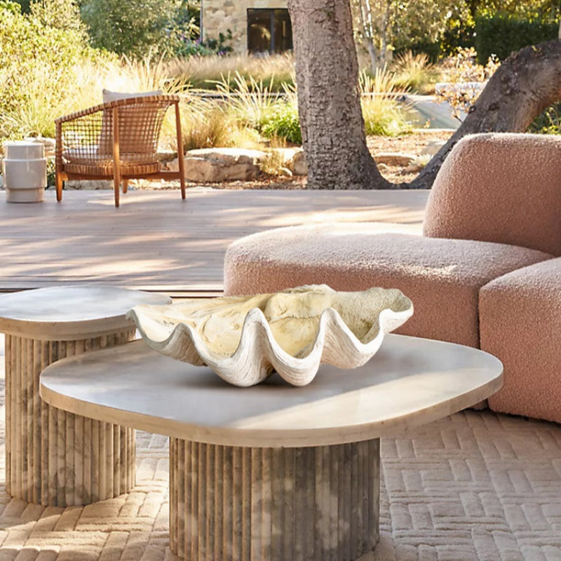 Large shell-inspired resin centerpiece bowl styled on an outdoor coffee table