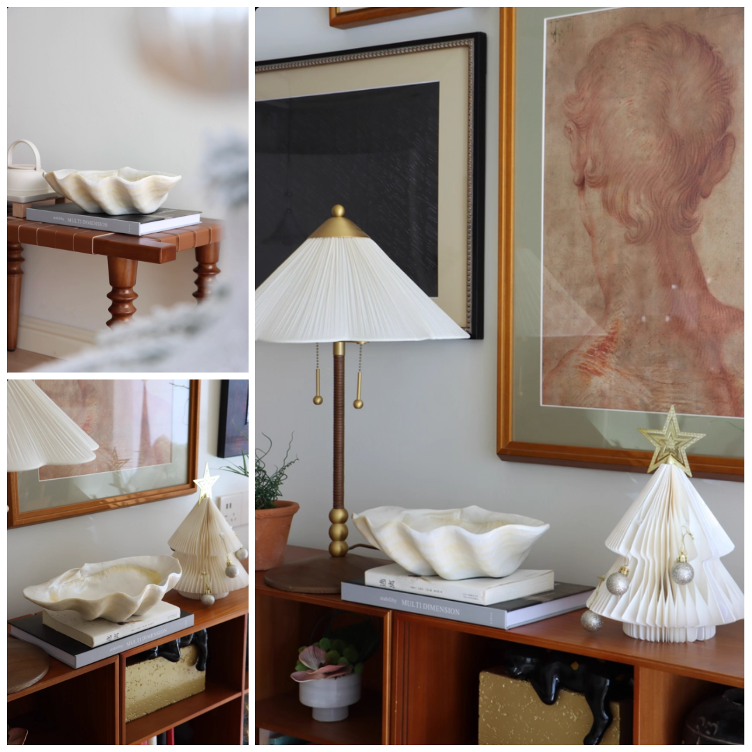Cream shell-inspired resin bowl displayed on shelves in a styled home interior