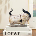 Side profile of abstract glass bull sculpture with black horns and gold flecks