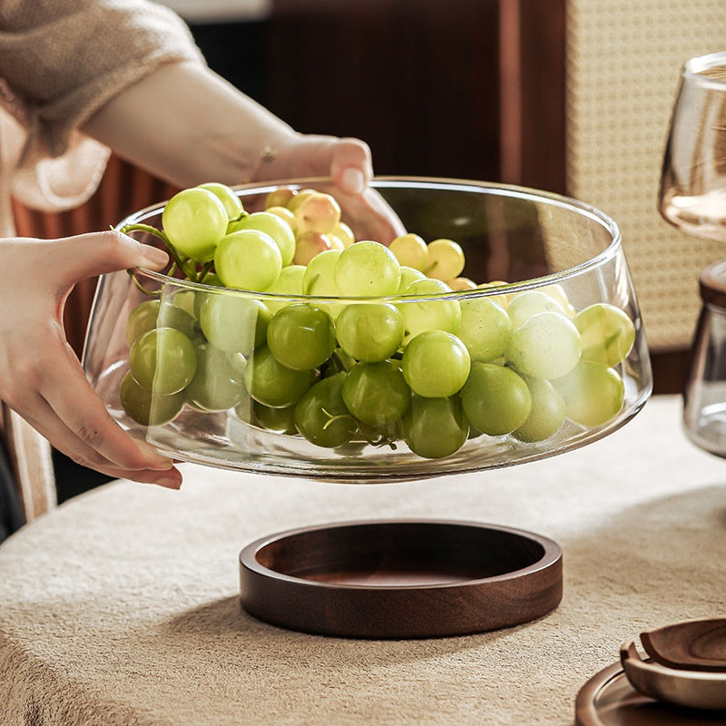 Clear glass fruit bowl with green grapes on walnut base