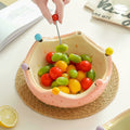 Glazed ceramic crown fruit bowl with forks holding cherry tomatoes