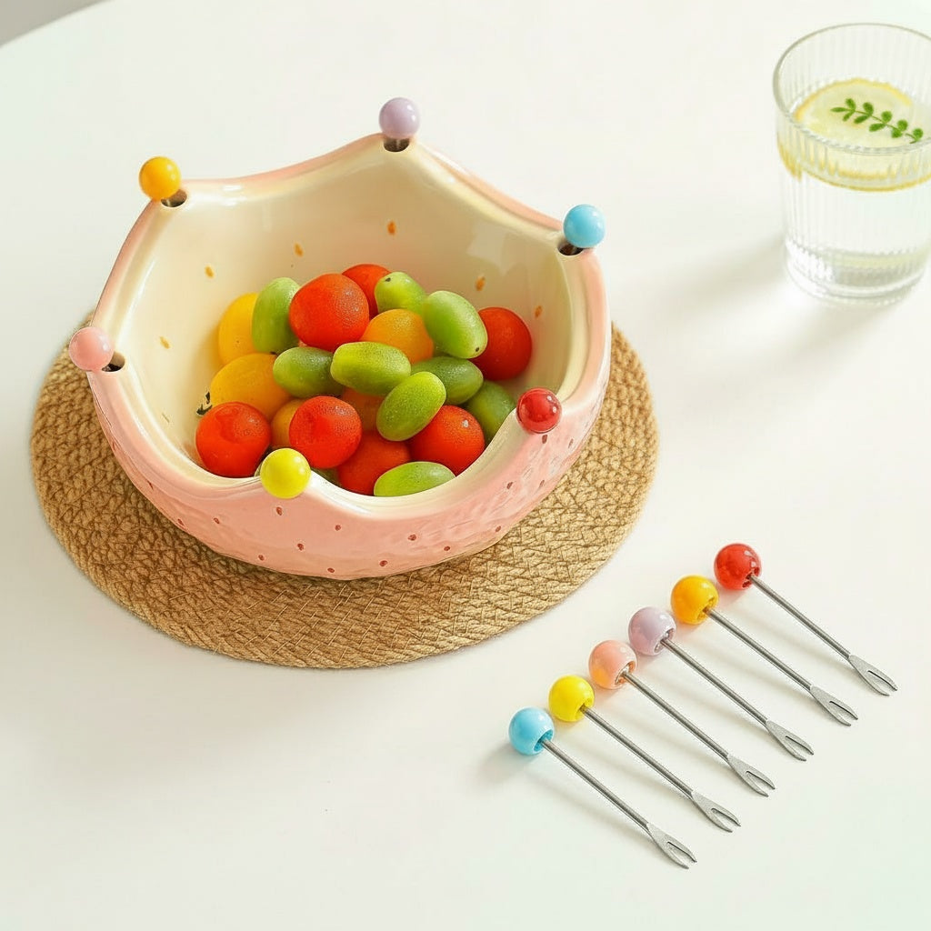 Glazed ceramic crown fruit bowl with colorful tasting forks laid out