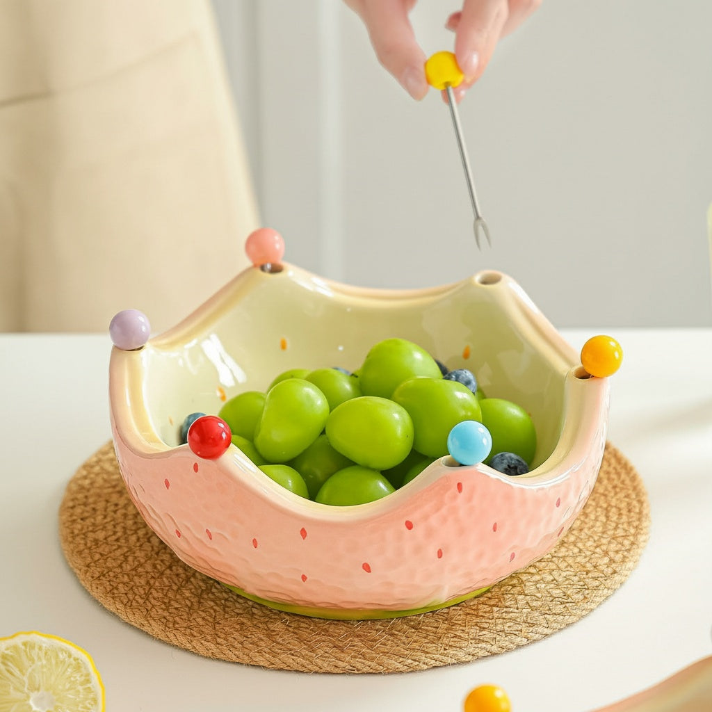 Hand using a yellow tasting fork with the glazed ceramic crown fruit bowl