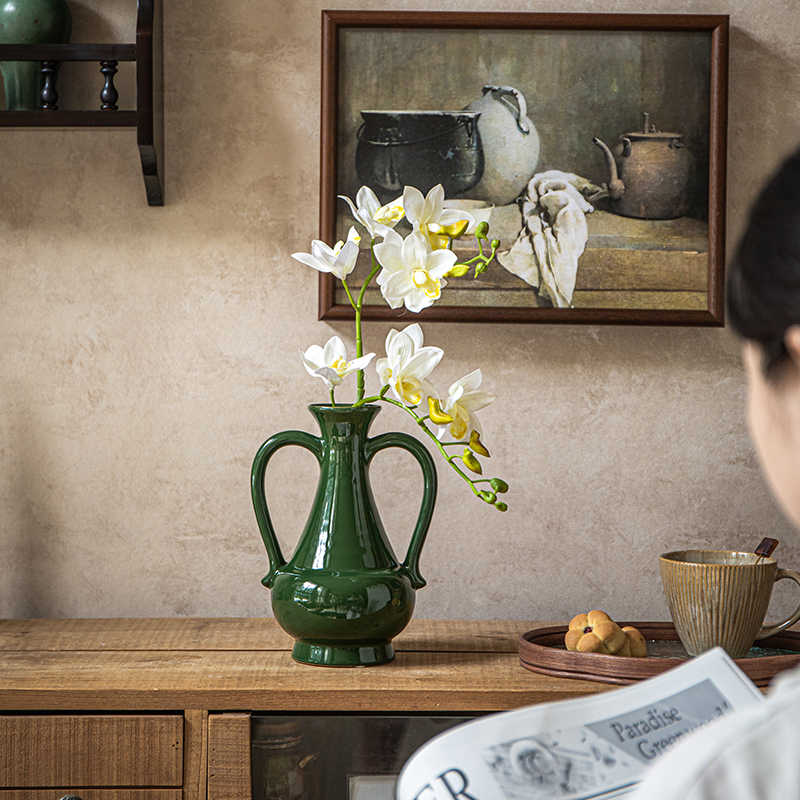 Green ceramic vase styled in a rustic interior setting