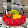 Glossy red fruit bowl with handle on marble table