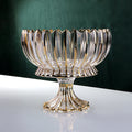 Front view of gold accented fluted glass fruit bowl on white table