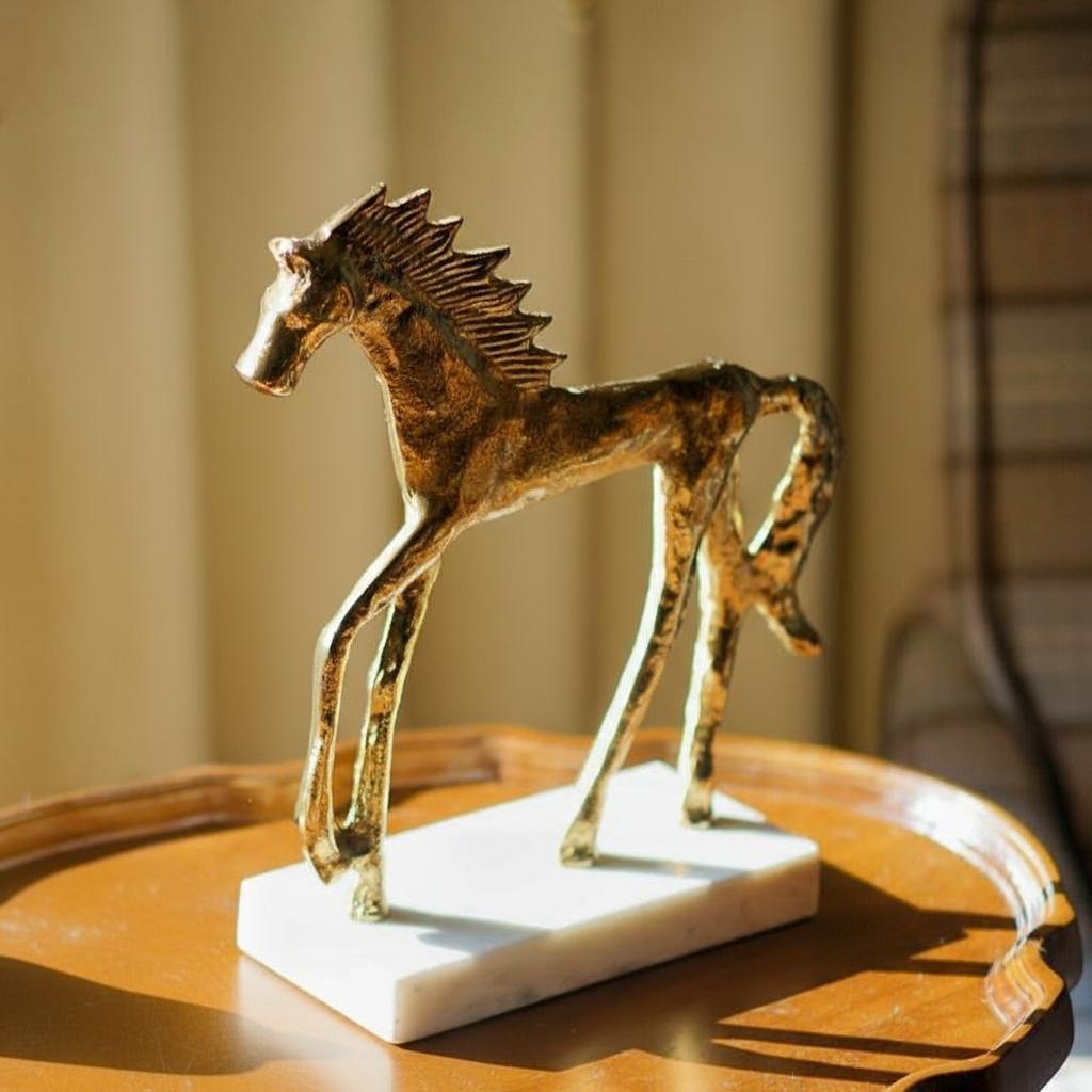 Back angle view of gold equestrian sculpture showing tail detail