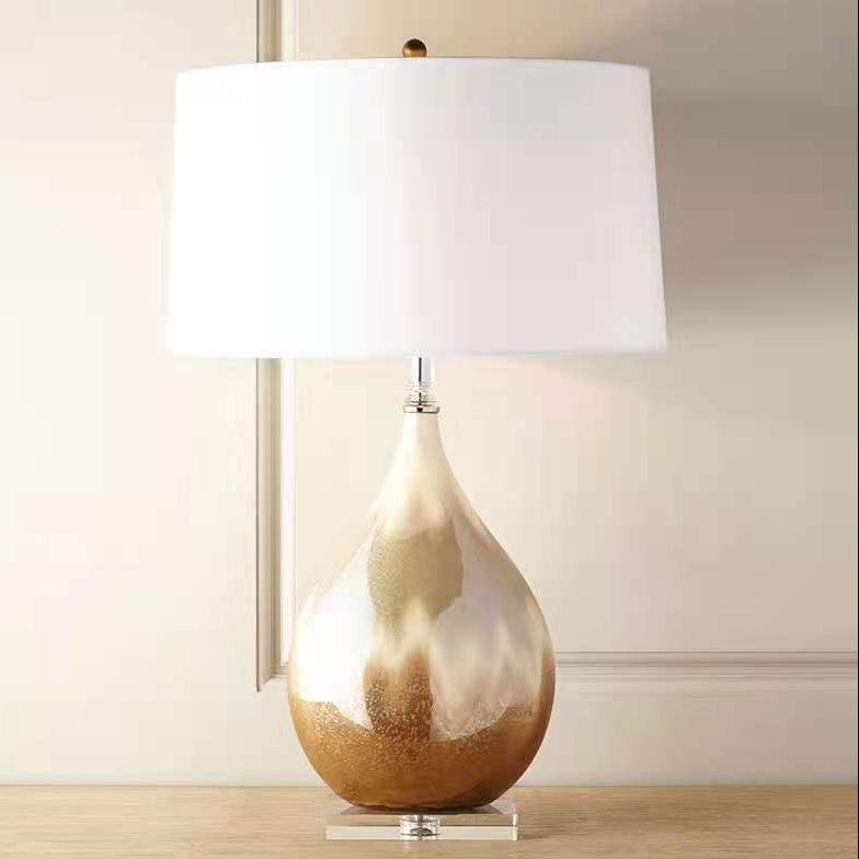 Front view of gold and cream ceramic table lamp with white shade