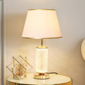 Front view of gold and crystal table lamp with white shade