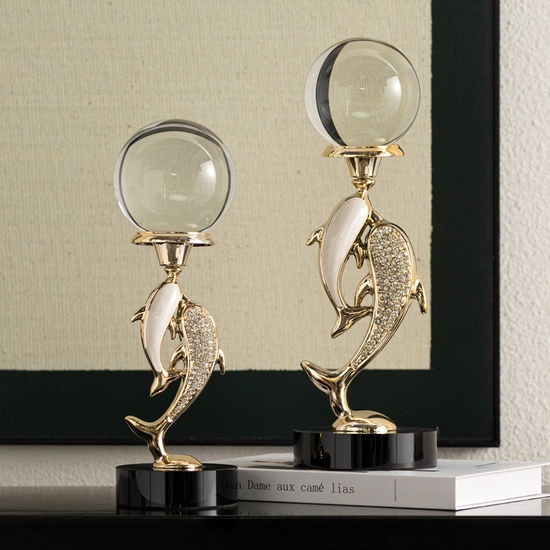 Large and medium gold dolphin sculptures side by side