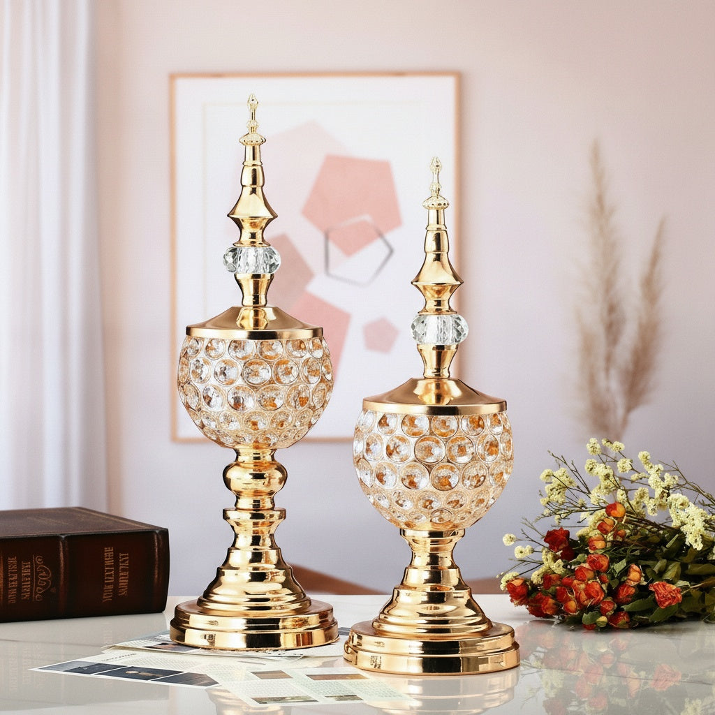 Two gold and crystal ornaments standing on a table