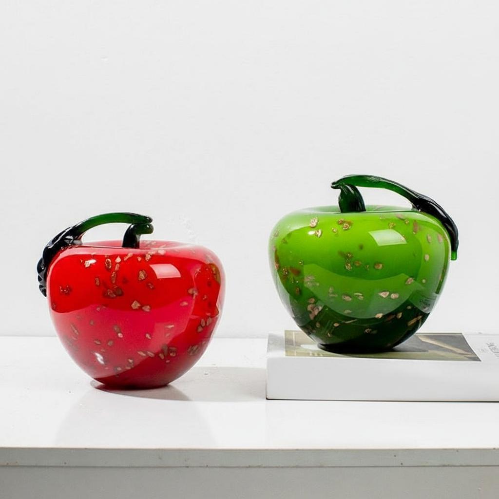 Red and green glass apple sculptures with gold flecks
