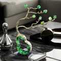 Front view of gold and green crystal tree sculpture on table