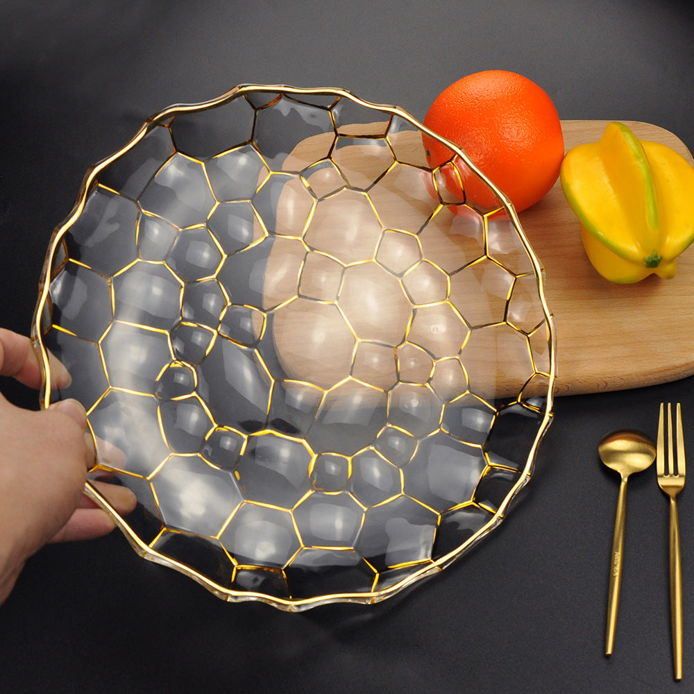 Hand holding the scalloped gold rim glass plate showing transparency