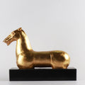 Side view of gold horse sculpture on black base