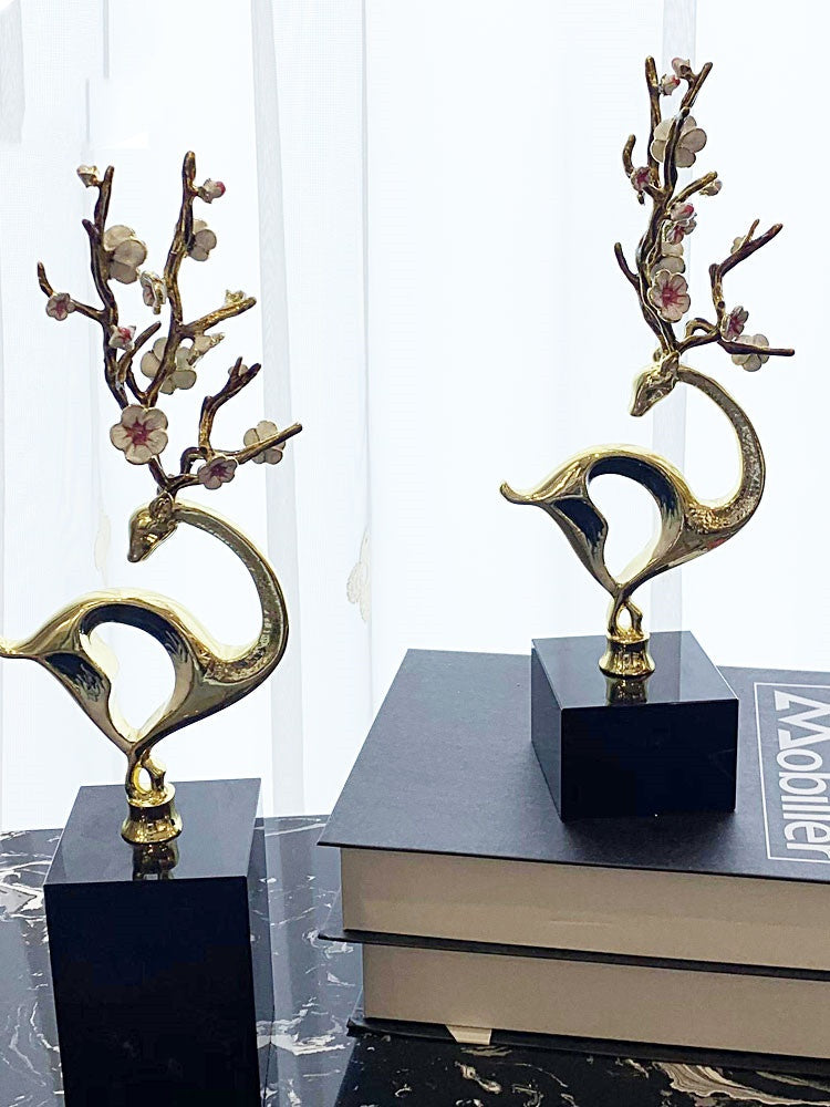 Front view of two gold deer sculptures on marble bases