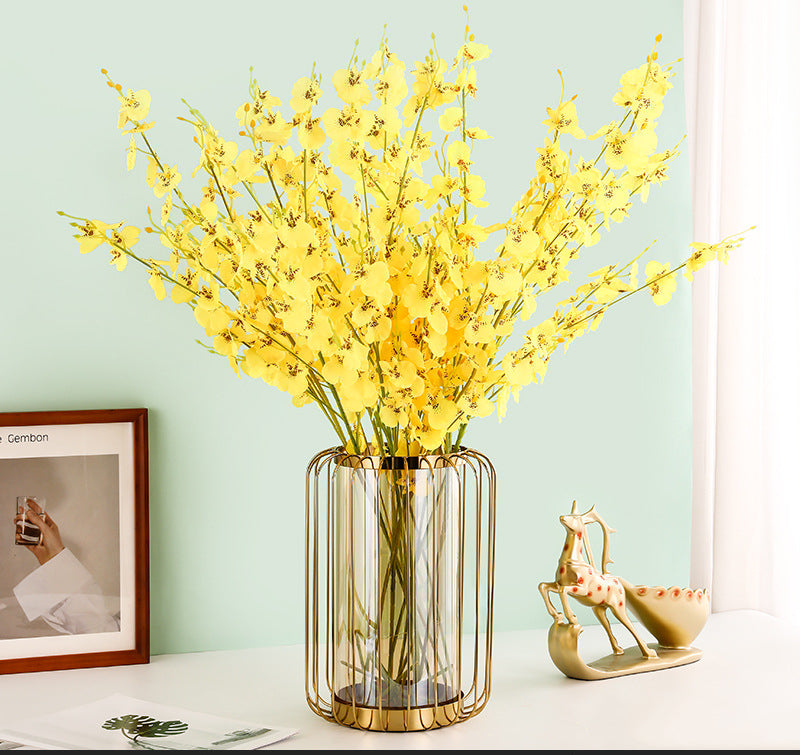 Lifestyle setting showing vase with yellow flowers on white table