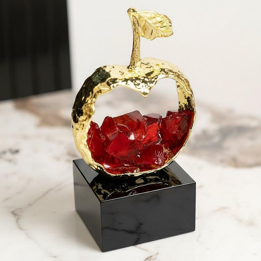 Front view of gold and red crystal apple sculpture on black base