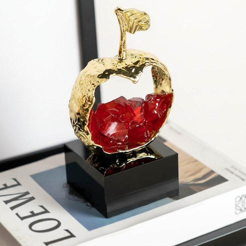 Side angle of gold apple sculpture on books