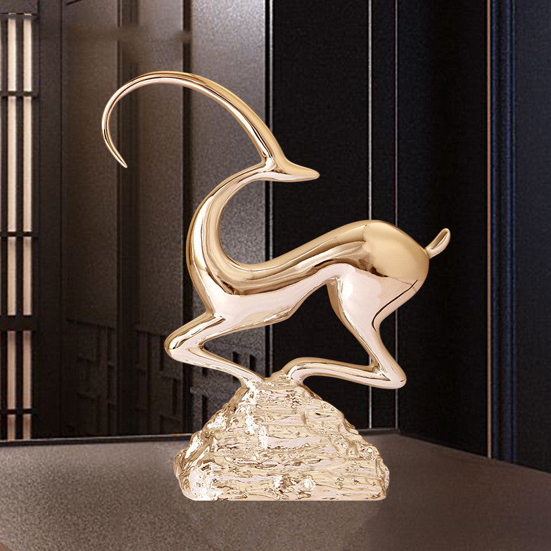 Gold resin abstract antelope sculpture side profile on textured base