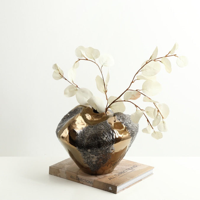 Front view of gold and textured ceramic vase with botanicals