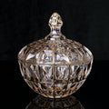 Front view of gold trimmed faceted glass candy jar on black background