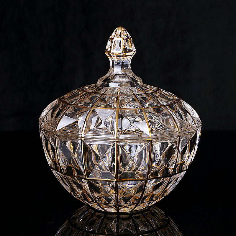 Front view of gold trimmed faceted glass candy jar on black background