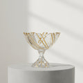 Gold veined crystal footed bowl with scalloped rim on wooden table