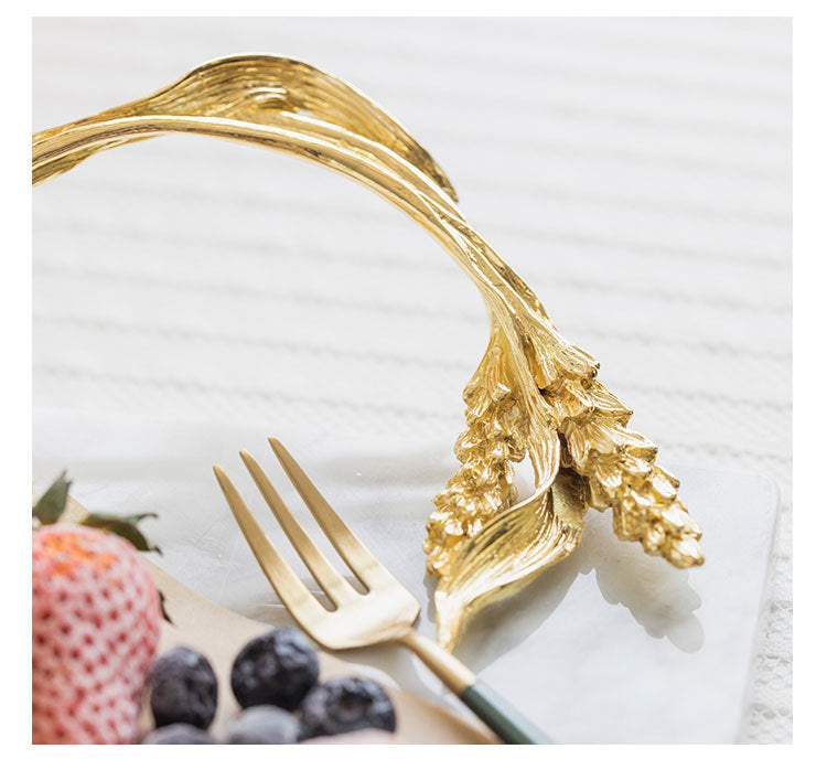 Close up detail of gold metal handle cast in the shape of wheat stalks attached to marble