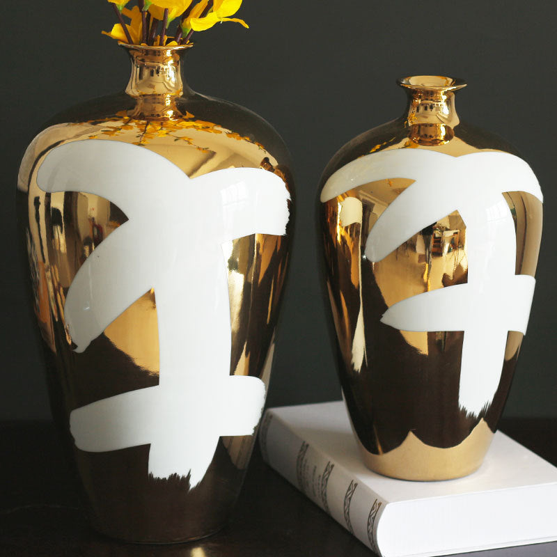 Close up of gold ceramic vase with white art detail