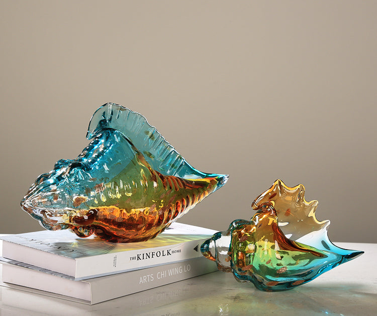 Side view of medium glass shell sculpture on book