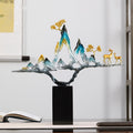 Front view of gradient blue mountain sculpture with gold deer