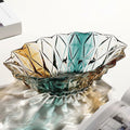 Faceted gradient glass centerpiece bowl with teal amber and clear tones on a modern table