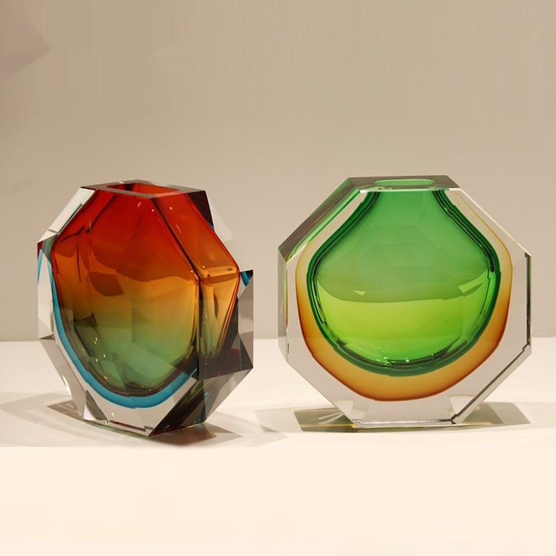 Red and green geometric faceted glass vases side by side